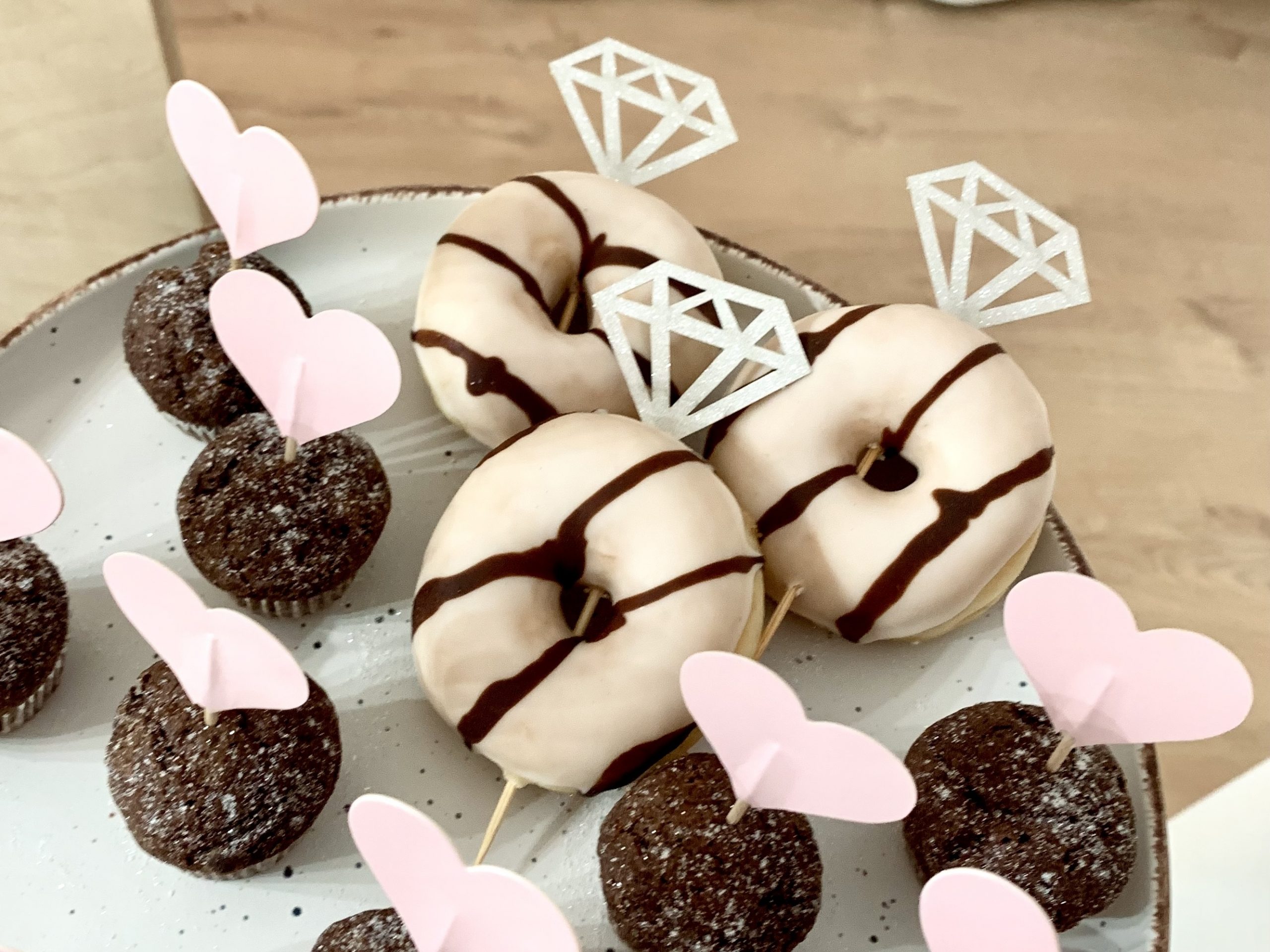 Donuts und Mini-Muffins, dekoriert mit Herzen und Diamanten für einen JGA