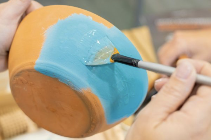 bemalten von einem terracotta pflanztopf für Kinder auf einem Kindergeburtstag workshop